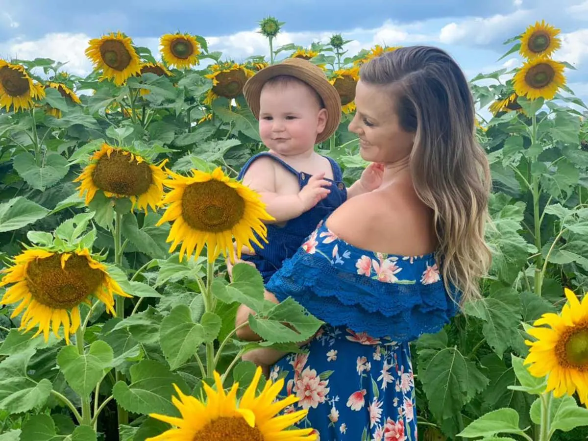 Visitors walking through flower rows at a New England farm.